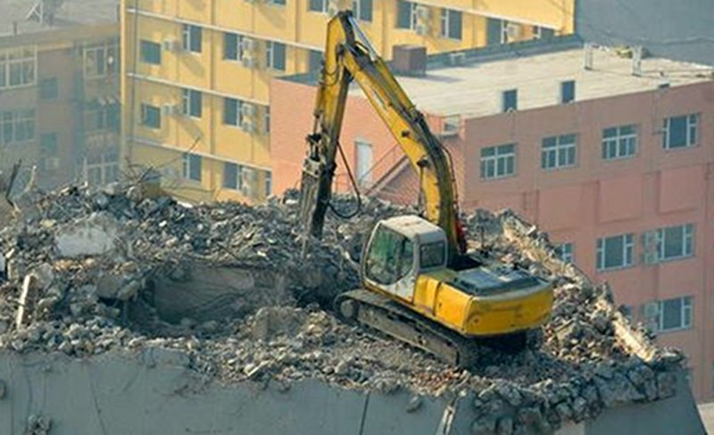 Illustration for article titled Why Is This Excavator Excavating A 12-Story Building From The Top Down?
